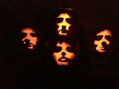 four pumpkins with faces carved into them in the shape of men's faces