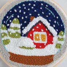 a handmade christmas ornament with a house on it