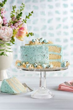 a cake with blue frosting and gold sprinkles on it sitting on a table