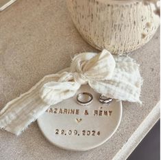 a wedding ring sits on top of a personalized memorial ornament next to a vase