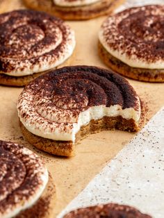 several cookies with white frosting and chocolate sprinkles on them sitting on a table