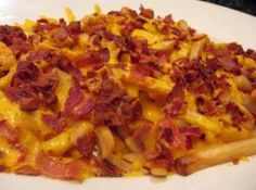 a white plate topped with cheesy potatoes and bacon