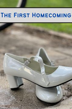 a pair of white shoes sitting on top of a cement ground next to a hose