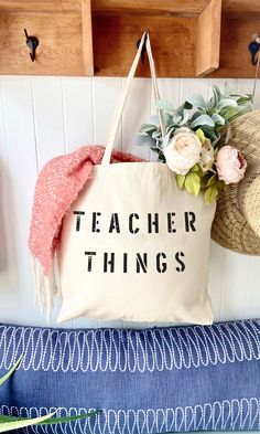 a tote bag with the words teacher things on it hanging from a coat rack