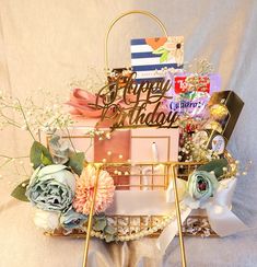 a birthday gift basket with flowers, candles and other items on it for someone's special occasion