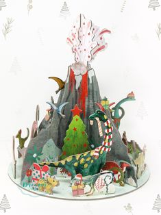 an origami christmas scene with trees, animals and birds on a mountain top