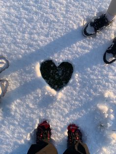 two people standing in the snow with their feet up