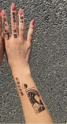 two people with tattoos on their hands are holding each other's hand and looking up at the sky