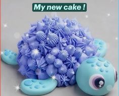 a blue turtle cake sitting on top of a white table next to a sign that says, my new cake