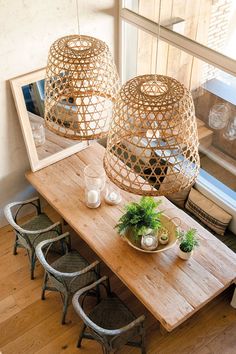 a wooden table topped with lots of chairs next to a mirror and potted plant