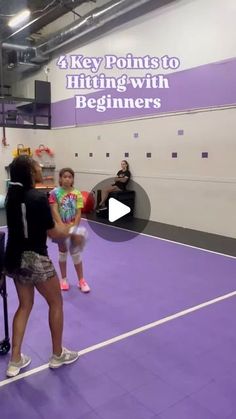 two women are standing on a purple tennis court and one is holding a racket