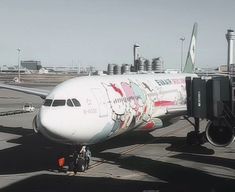 an airplane with hello kitty painted on it's side is parked at the airport