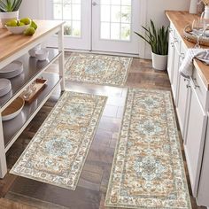 three rugs in the middle of a kitchen with white cabinets and wooden flooring