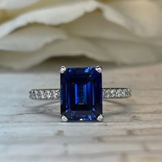 an emerald cut blue sapphire ring with diamond accents