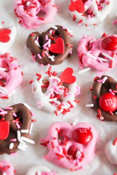 valentine's day donuts with sprinkles and hearts are on the table