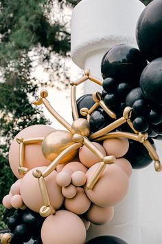 balloons are attached to the side of a tall tower with black and white balloons on it