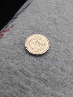 a small coin sitting on top of a piece of cloth