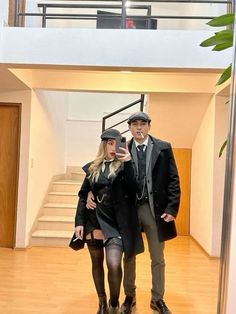 a man and woman standing in front of a staircase taking a selfie with their cell phone