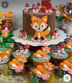 cupcakes decorated like foxes and mushrooms on a table