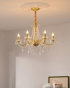 a chandelier hanging from the ceiling in a room with a painting on the wall