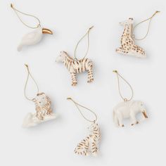 four ceramic animal ornaments in various shapes and sizes on a white background with gold accents