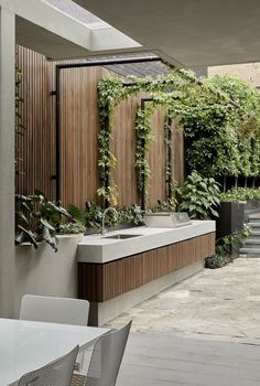 an outdoor kitchen with plants growing on the wall