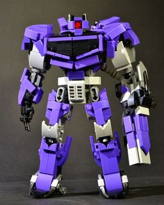 a purple and white robot standing on top of a table