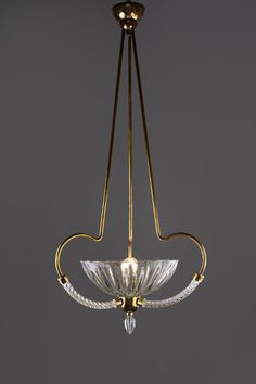 a chandelier hanging from the ceiling with glass shades and gold trimmings