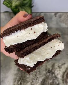 someone is holding two brownie sandwiches with ice cream on them, and they are half eaten