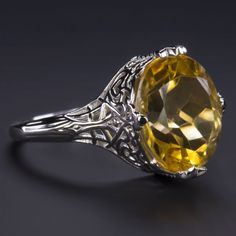 This beautiful and unique solitaire ring features a 4.75ct oval cut citrine set in a classically elegant vintage style design that will never go out of style! Measuring approximately 12mm across, the citrine has a substantial look and a gorgeous sunny yellow hue. Utterly classic and romantic, the antique style setting is richly textured with intricate engraving and graceful filigree. The effect is chic but also dreamy and softly feminine, a perfect choice for a timeless gift or a treat for yours