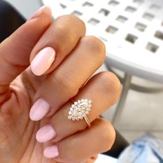 a woman's hand with pink manies and a ring