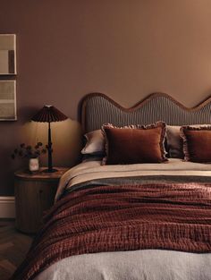 a bedroom with a bed, night stand and two lamps on either side of the bed