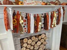 a fireplace decorated for fall with pumpkins and ribbons