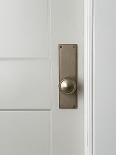 an open door with a metal knob on it's side and white walls in the background