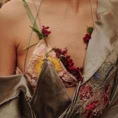 a close up of a person wearing a dress with flowers on it's chest