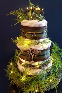 a three tiered cake decorated with ribbons and lights