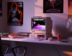 an old computer sitting on top of a desk next to a fan and other items