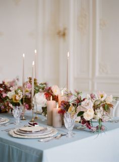 the table is set with flowers and candles