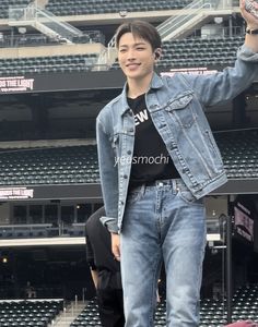 a young man standing on top of a skateboard in front of an empty bleachers