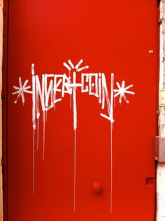 a red door with white spray paint on it and the word inferethn painted on it