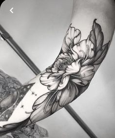 a black and white photo of a person's arm with flowers on the side