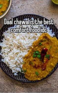 a black plate topped with rice and curry next to a bowl filled with white rice