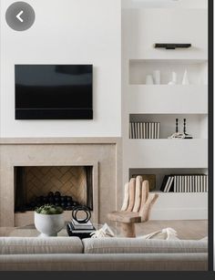 a living room with white walls and a fireplace