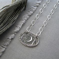 "This lovely necklace has a light and airy look with plenty of shine. The graceful crescent moon casts a silvery light on the forest below. After sketching the design I carved it carefully into a lino block, line by line. I press each moon pendant in recycled 99.9% pure silver from my original carving. You'll love the luminous moon, and the intricate detail and texture of the branches, leaves, and plants. I would be happy to personalize this for you at no extra charge; up to 15 characters may be Nature-inspired Sterling Silver Moon Charm Jewelry, Silver Moon-shaped Nature-inspired Jewelry, Nature-inspired Silver Moon Shaped Jewelry, Nature-inspired Silver Moon Jewelry, Handmade Moon Shaped Nature-inspired Necklace, Lino Block, Forest Moon, Recycled Silver, Lovely Necklace