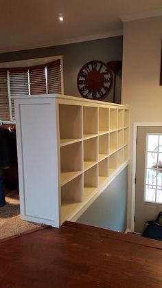 a living room with bookshelves and a door leading to another room in the background