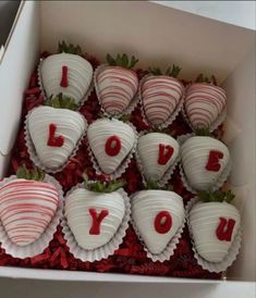 chocolate covered strawberries in a box with the word i love you written on them