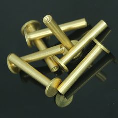 several brass screws on a black surface