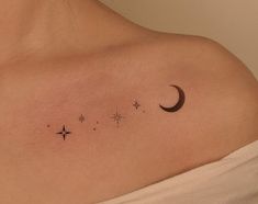 a woman's shoulder with three stars and a crescent tattoo