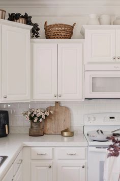 a kitchen with white cabinets and appliances in it