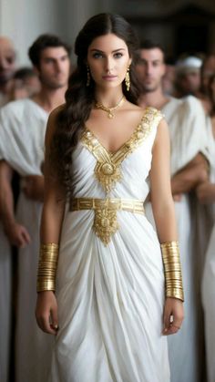 .   Woman in white peplos and gold jewelry standing in front of a group of people, Greek beautiful woman, delicate face, graceful figure, luxury of golden long hair, elegant ancient Greek peplos, dressed in ancient Greek clothes, bracelets, ornament on the walls Roman Empire Costume, Greek Oracle, Greek Girl Aesthetic, Greek Princess, Ancient Greek Outfit, Ancient Greek Clothing Woman, Greek Goddesses, Greek Goddess Outfit, Ancient Greece Clothing